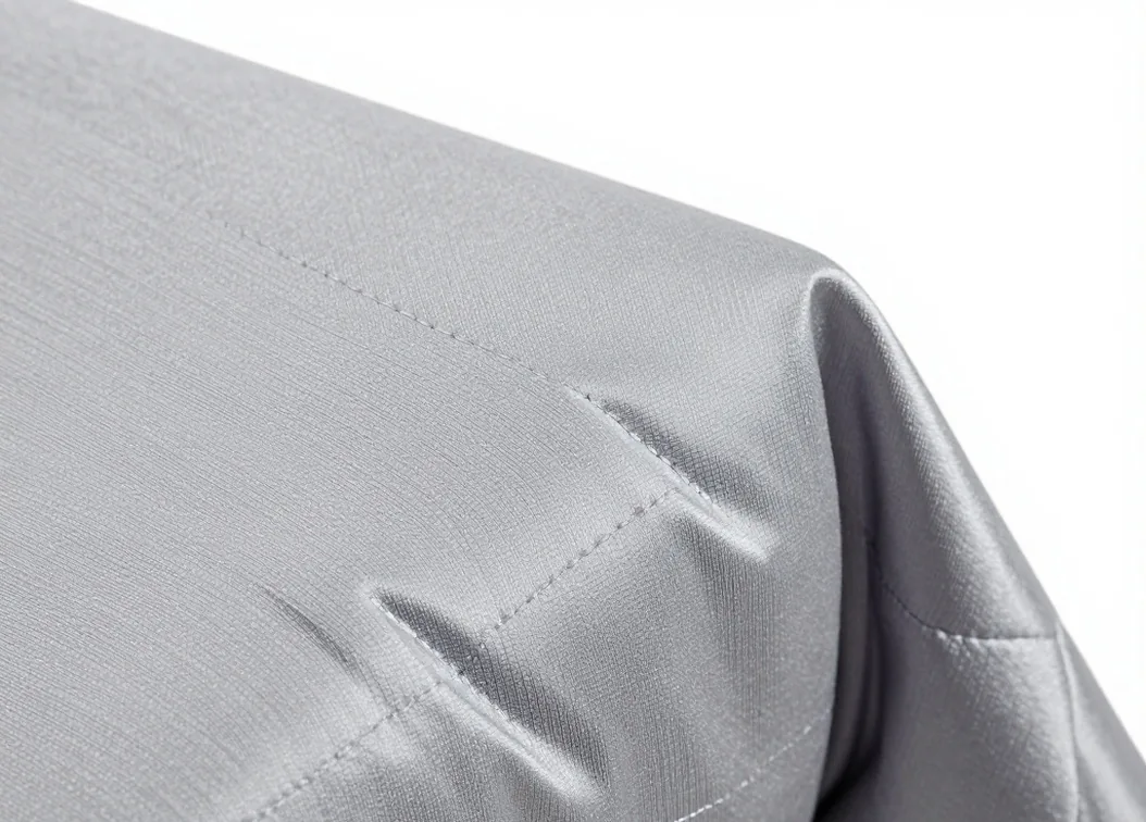 Macro close-up of a cool silver-grey bamboo viscose weighted blanket corner showing the silky weave
